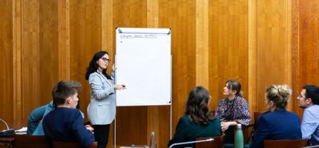 Raquel Munayer (adelphi) in the centre writing on the board during a breakout session Breakout Working Session at BCSC2024